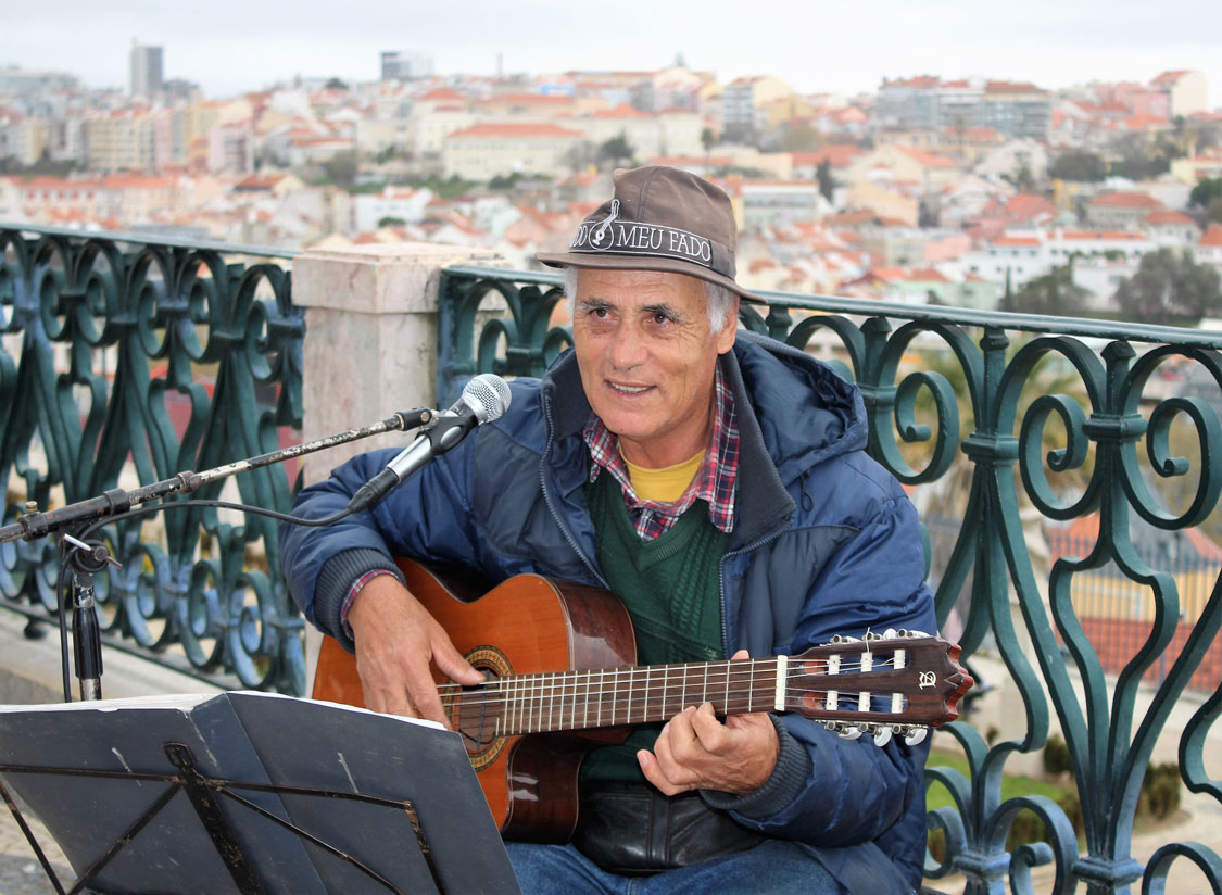 Fado singer, with a mosaic of red rooftops stretching out behind.