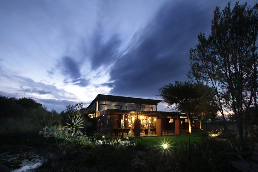 eco-retreat at night with lit up garden