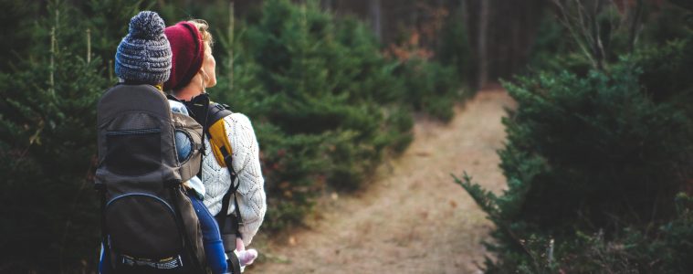 a mom hiking in the forest with her baby