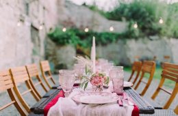 a table set outside with pink decor