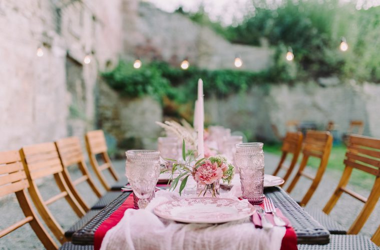 a table set outside with pink decor