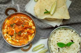 a dish with chicken stew in it alongside some rice