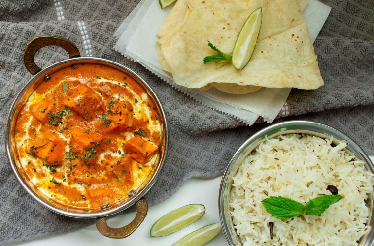 a dish with chicken stew in it alongside some rice