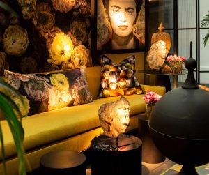 a well-deigned room, dimly lit with a Frida Kahlo painting on the wall