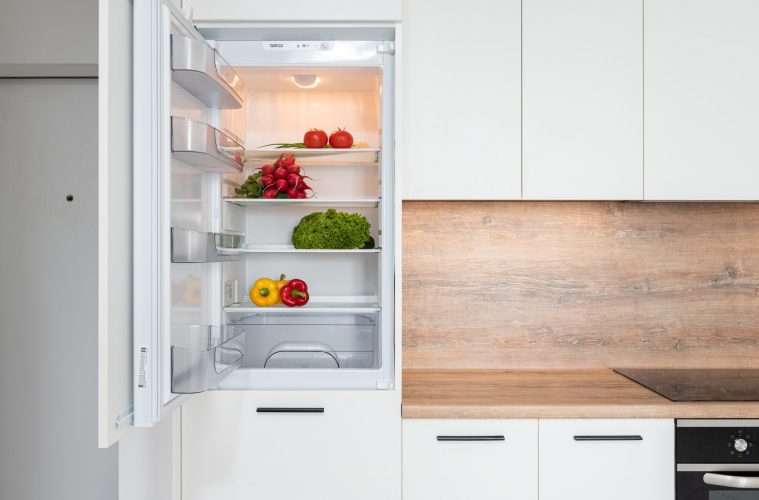a fridge with the door open and veggies inside