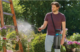 a man watering plants in his garden