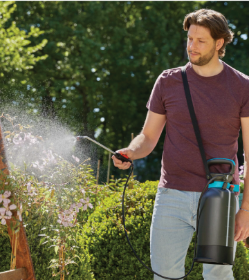 a man watering plants in his garden