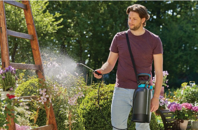 a man watering plants in his garden