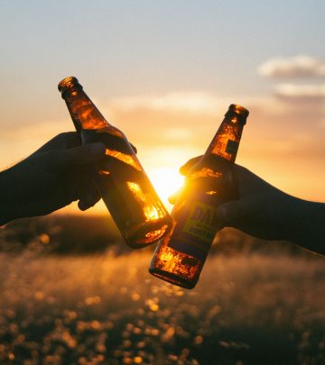 two people toasting with beer bottles