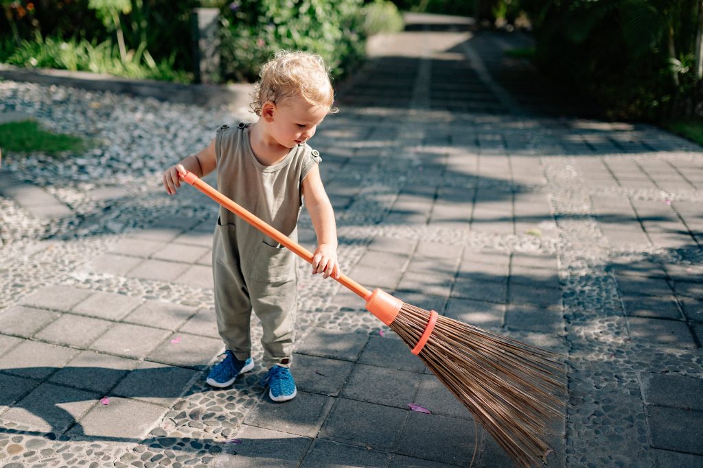 a little kid cleaning the garden