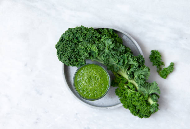 Kale Juice Green smoothies with kale, banana, apple and pear and lemon on marble background with copy space