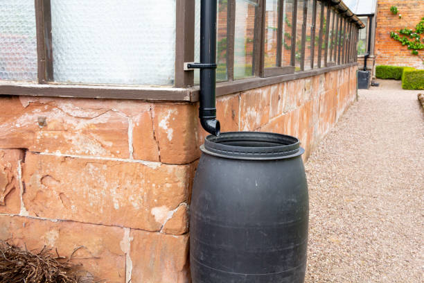 Rain Barrels Water butt collects rain water from the roof of old fashion sandstone greenhouses , saving water and helping fight water shortages and drought.