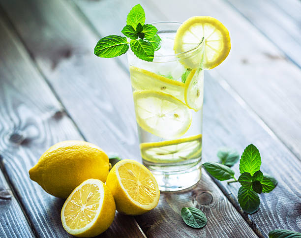 Fresh water with lemon slices and mint on the wooden table. Tined picture, taken with Canon 5D mkIII