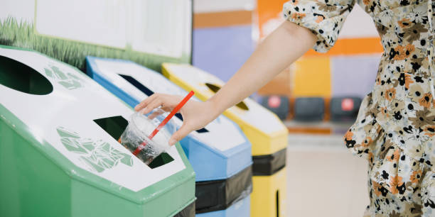 Woman throwing something at recyle bins