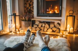 A couple on a lazy winter day in front of fire in fireplace.