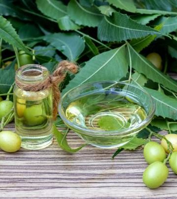 Neem Oil in a Glass Bowl and Bottle with Neem Leaves and its fruit.