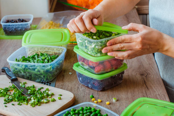 Woman preserving foods in containers before freezing