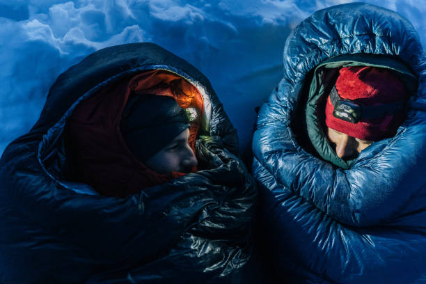 Two man in sleeping bags on camp