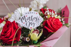 Happy Mothers Day text on gift card with flower bouquet of roses, tulips