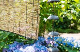 Rain chains and bamboo blind hanging before a Japanese garden