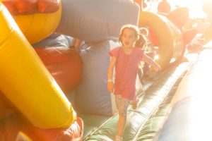 Happy little girl having lots of fun on a jumping castle during sliding