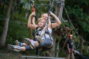 mother and son having fun on a zipline