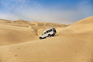 A four wheel drive vehicle descends the sand dunes between Walvis bay and Sandwich harbour.