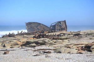 Scattered remains of a ship wreck in the mist on the South African Northern Cape Namaqualand Skeleton Coast