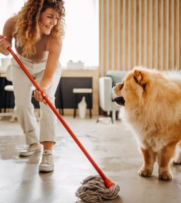 Housewife and her dog mopping on the floor